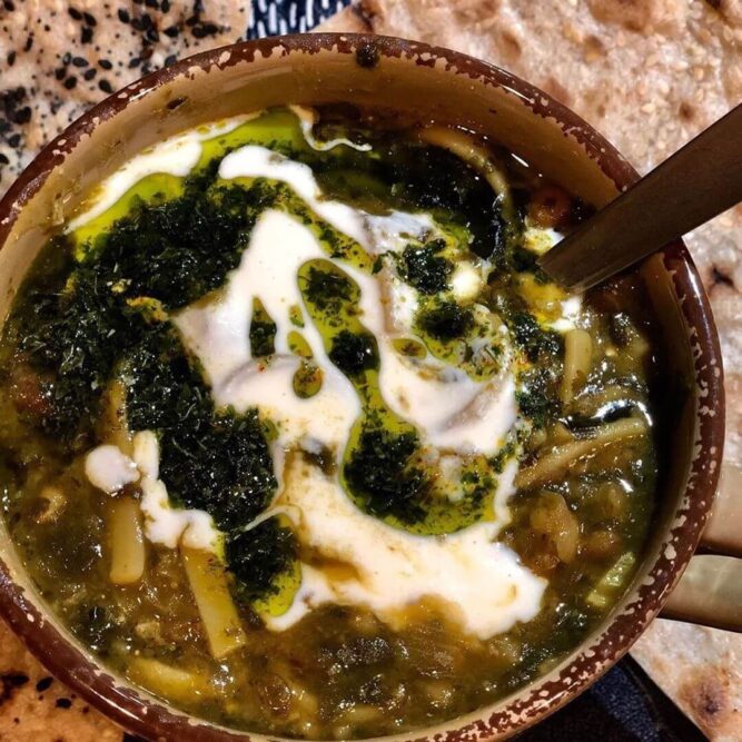 Persian-Herb-Noodle-Soup-Ash-Reshteh-with-Sangak-Breadmasters - Breadmasters Persian Herb Noodle Thick Soup (Ash Reshteh) served with crispy ARA-Z Sangak flatbread pieces - Traditional Iranian herb, bean, and noodle soup, perfect for dipping with authentic stone-baked sangak | Vegan-friendly Persian comfort food pairing from Breadmasters