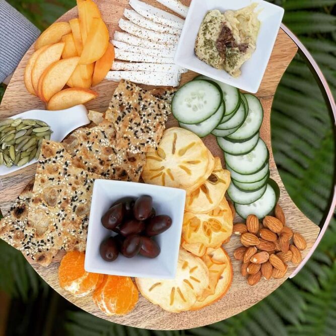 Sangak Crisps Charcuterie Board - Breadmasters Sangak multi-seed crisps on charcuterie board with cheese, persimmon, cucumber, almonds, and olives